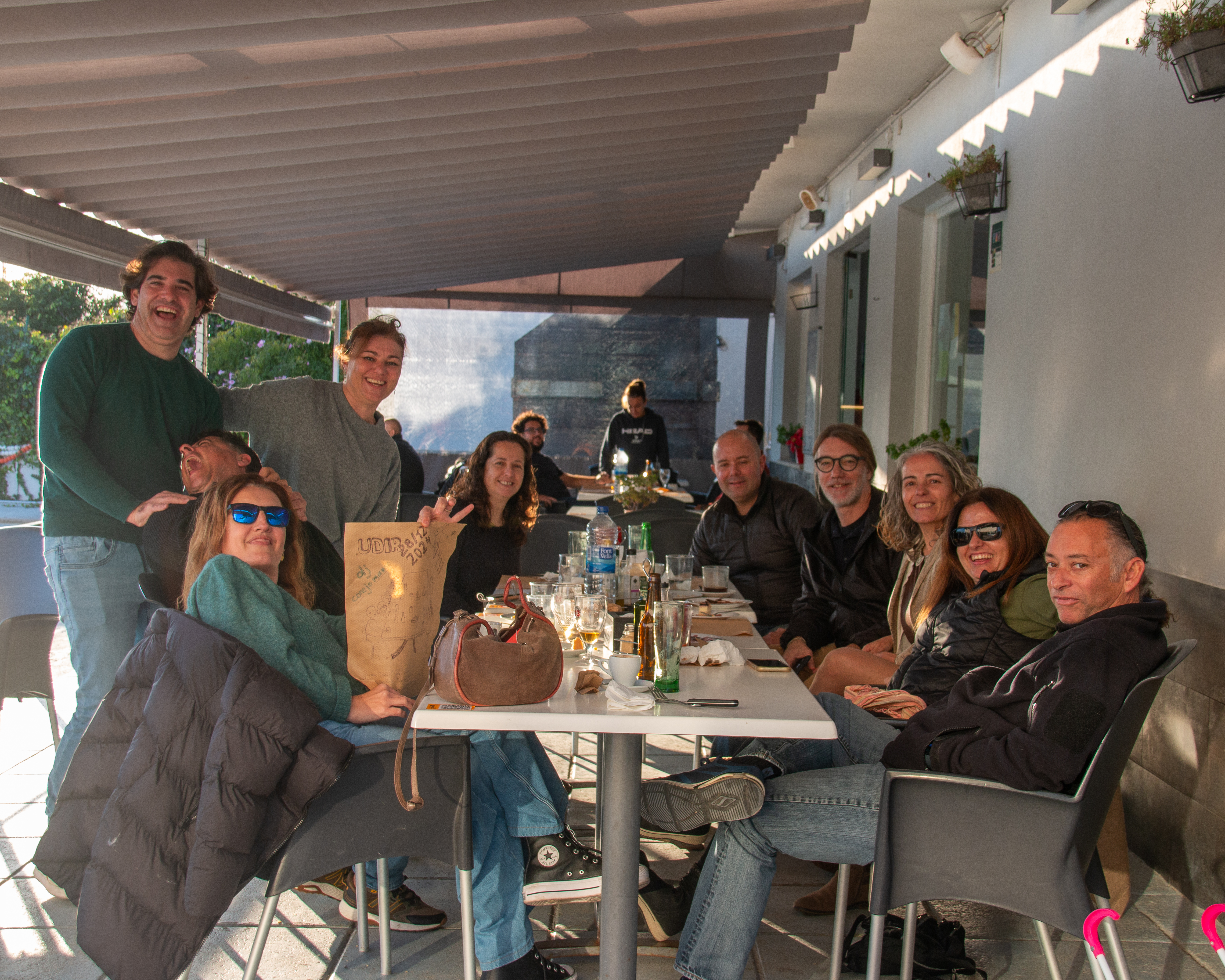 Grupo de amigos celebrando una comida en la terraza junto a la piscina