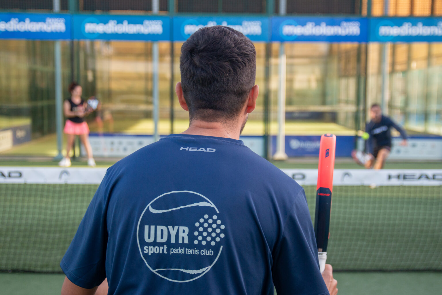 profesor de espaldas y hombre y mujer entrenando con él