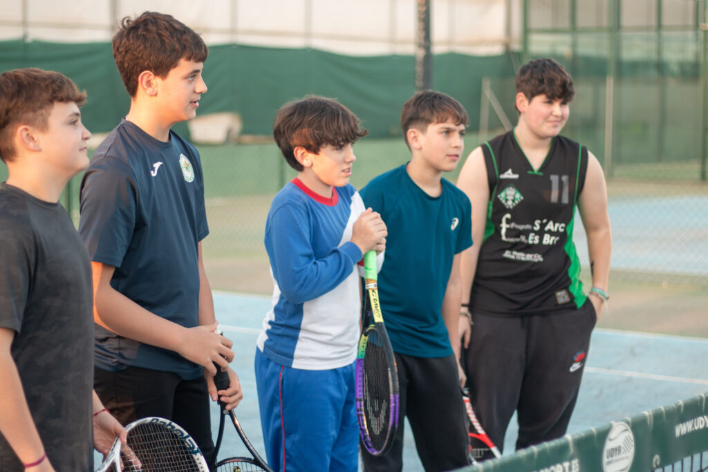 niños atendiendo al profesor durante su clase de tenis